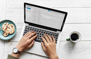 Muž pracující na laptopu u dřevěného stolu